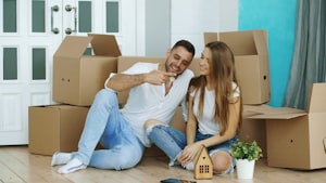 A couple sitting among moving boxes in a new home